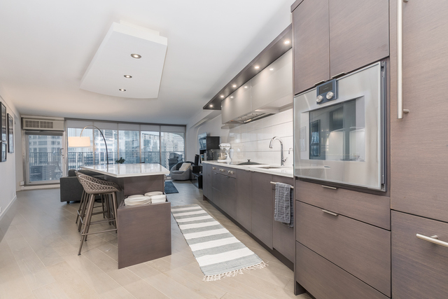 300 North State Street, Unit 2512 Chicago, IL 60654 - Photo 7 of 17 a large kitchen with kitchen island a counter space a sink a window and stainless steel appliances