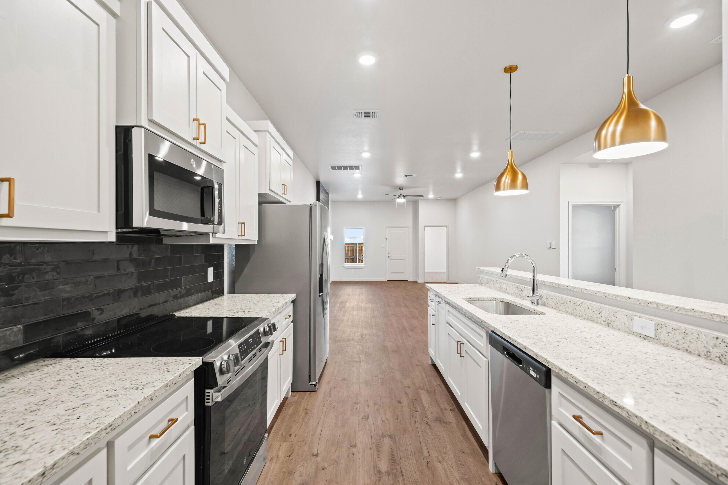 7014 40th Street, Unit A Lubbock, TX 79407 - Photo 7 of 19 a kitchen with stainless steel appliances granite countertop a sink a stove and a wooden floors