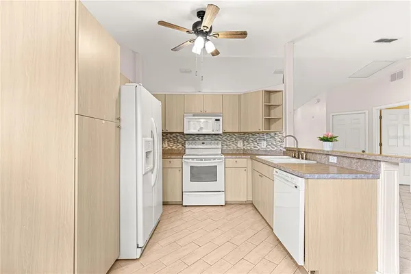 a kitchen with stainless steel appliances white cabinets and white appliances
