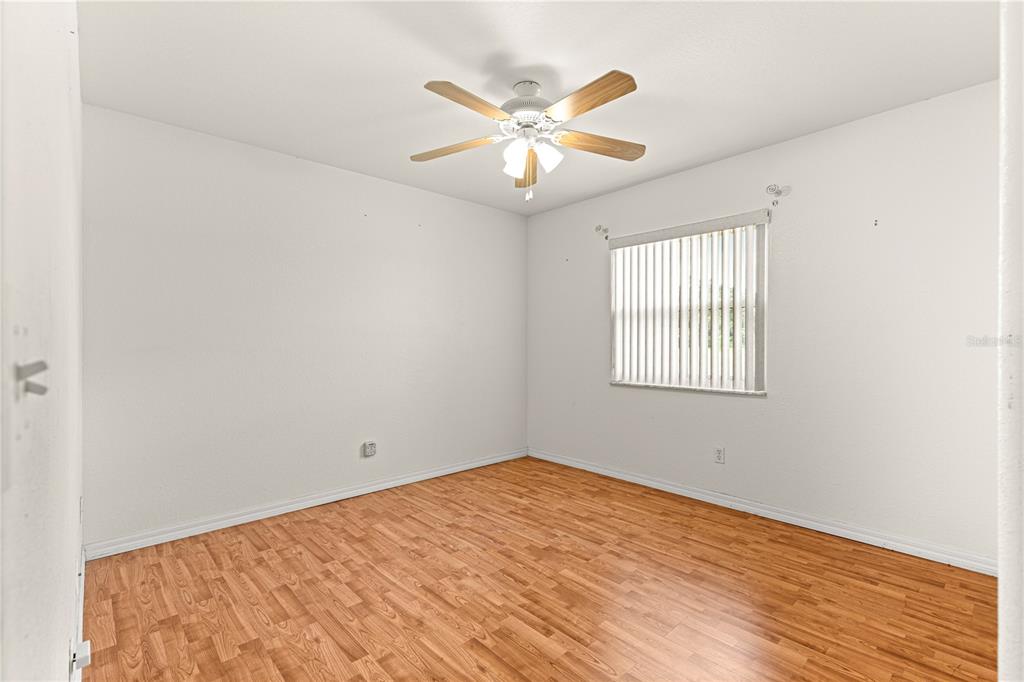 9958 Southwest 59th Circle Ocala, FL 34476 - Photo 21 of 45 an empty room with wooden floor and windows
