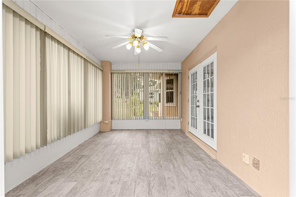 9958 Southwest 59th Circle Ocala, FL 34476 - Photo 22 of 45 an empty room with wooden floor fan and windows