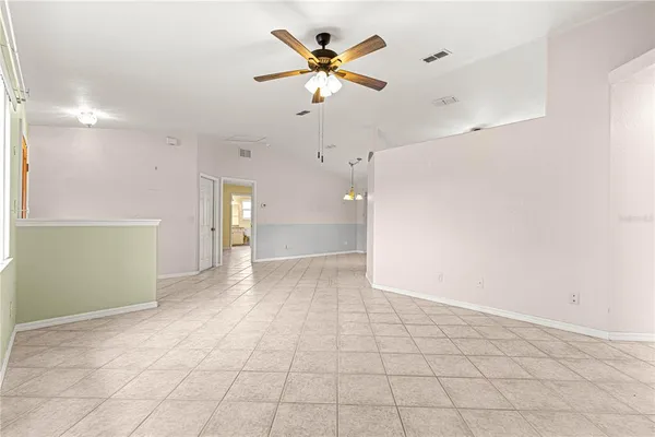 a view of an empty room and a ceiling fan