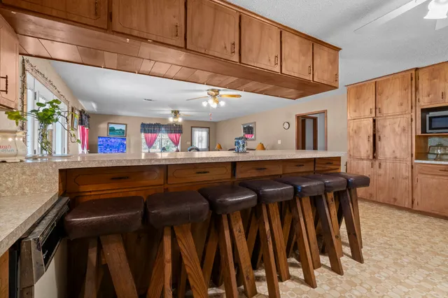 a kitchen with stainless steel appliances granite countertop a stove a sink dishwasher and a refrigerator with wooden cabinets