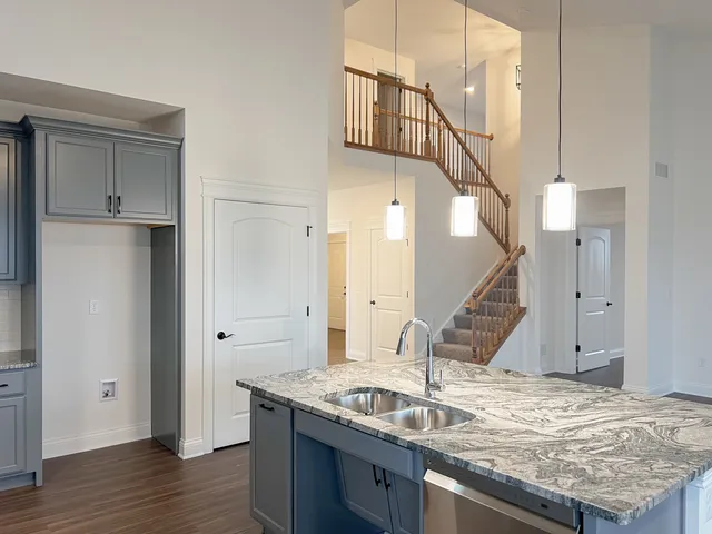 a kitchen with kitchen island a sink and a wooden floor