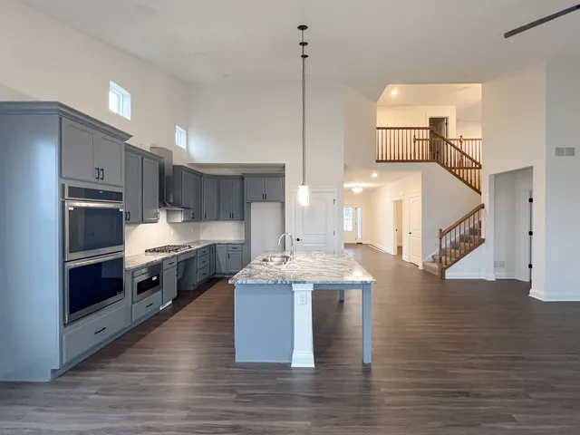 a kitchen with stainless steel appliances kitchen island granite countertop a stove a sink and a refrigerator