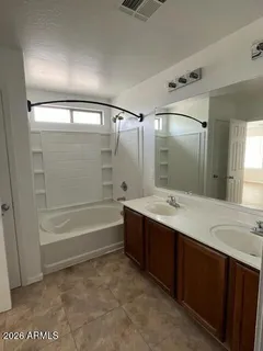 a bathroom with a tub sink shower and mirror