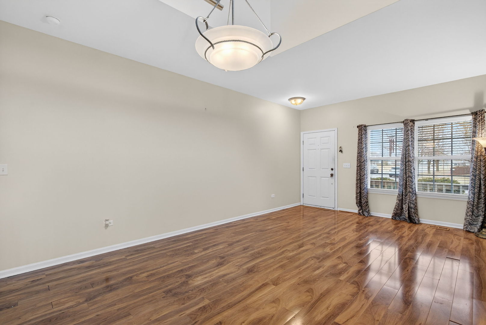 1451 Red Top Lane Minooka, IL 60447 - Photo 4 of 37 a view of an empty room with wooden floor and a window