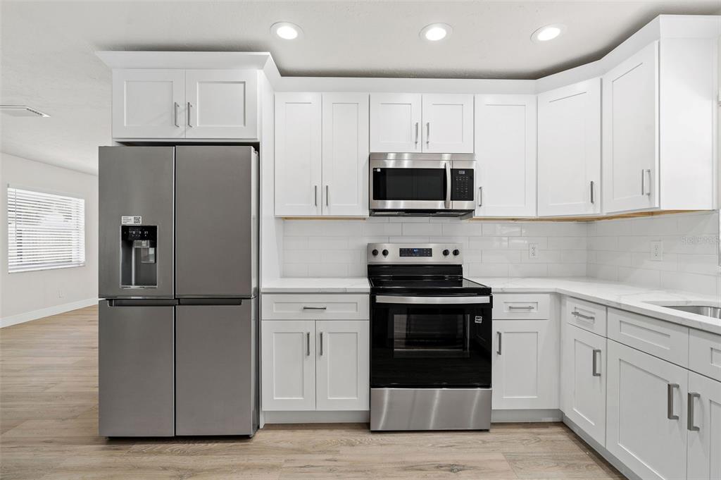 5207 Burr Place Seffner, FL 33584 - Photo 11 of 43 a kitchen with cabinets stainless steel appliances and wooden floor