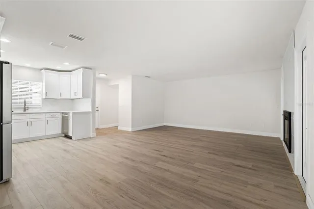 a view of a kitchen with wooden floor and electronic appliances