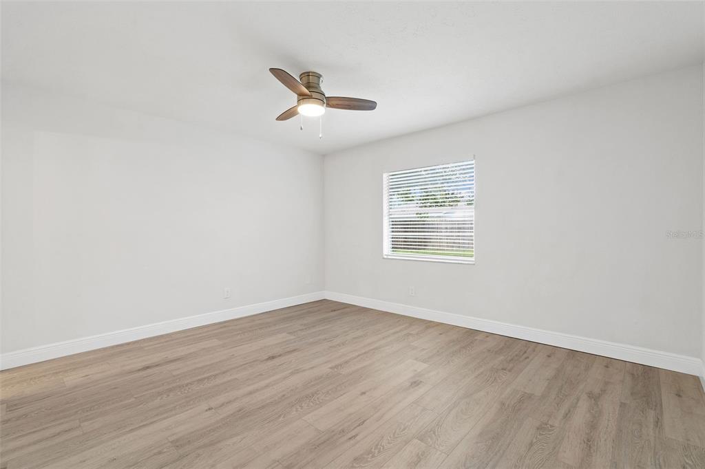 5207 Burr Place Seffner, FL 33584 - Photo 15 of 34 an empty room with wooden floor fan and windows