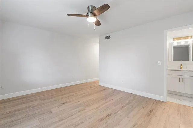 a view of a room with wooden floor and ceiling fan