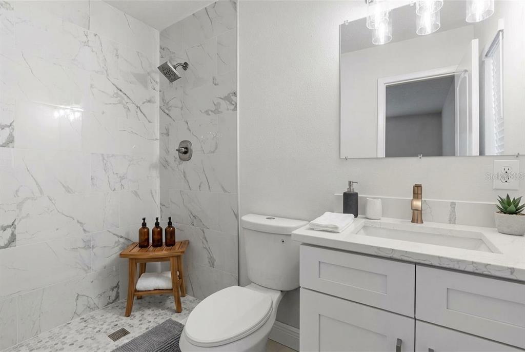 5207 Burr Place Seffner, FL 33584 - Photo 21 of 43 a bathroom with a granite countertop toilet sink and mirror