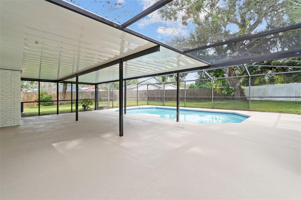 5207 Burr Place Seffner, FL 33584 - Photo 26 of 34 a view of an empty room with wooden floor and a small yard