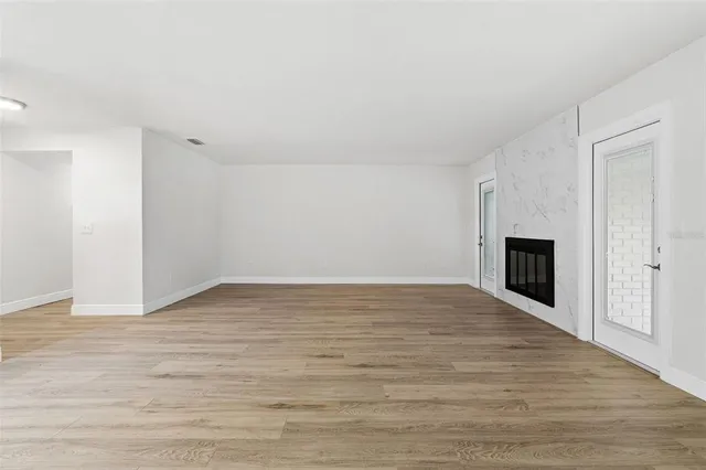 a view of empty room with wooden floor and fireplace