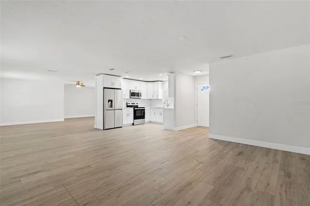 a view of a kitchen with a sink and a refrigerator