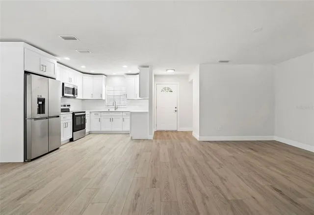 a view of kitchen with wooden floor and electronic appliances