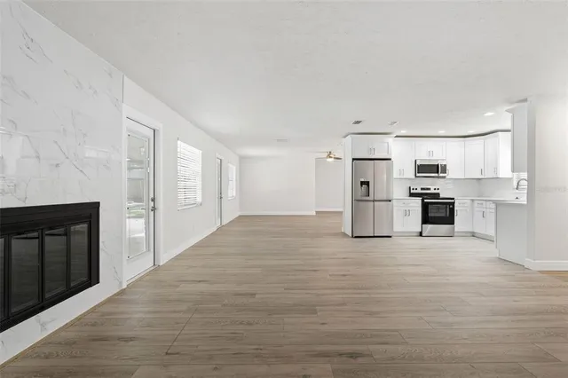 a large white kitchen with white cabinets and stainless steel appliances