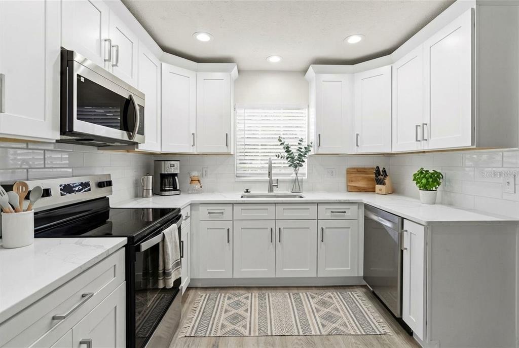 5207 Burr Place Seffner, FL 33584 - Photo 9 of 43 a kitchen with a sink stove and microwave
