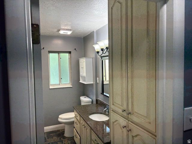 2313 150 East Bountiful, UT 84010 - Photo 23 of 39 Bathroom featuring extensive built-in cabinetry, a stone-finish countertop with an undermount sink, a large vanity mirror, and slate-finish floor tiling