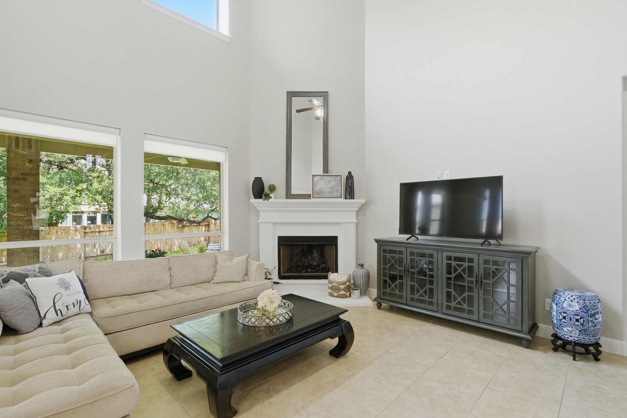 110 Dasher Drive Cedar Park, TX 78613 - Photo 7 of 39 A graceful fireplace anchors this airy living area, featuring soaring ceilings and bright windows overlooking green views.