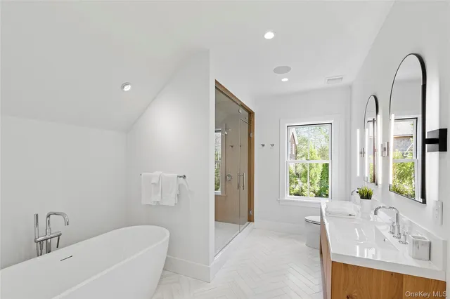a spacious bathroom with a granite countertop sink a mirror and a shower