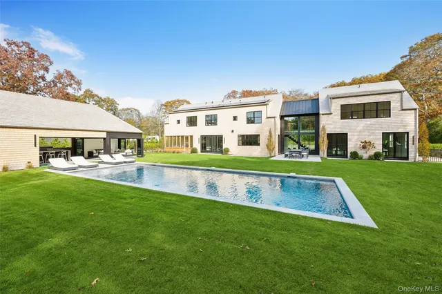 a view of house with a big yard and large trees