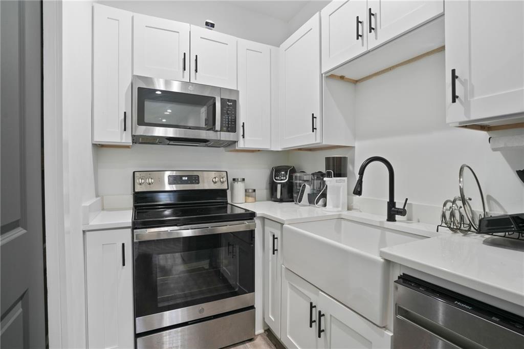 3120 Godby Road, Unit 1107 Atlanta, GA 30349 - Photo 7 of 29 a kitchen with white cabinets and stainless steel appliances