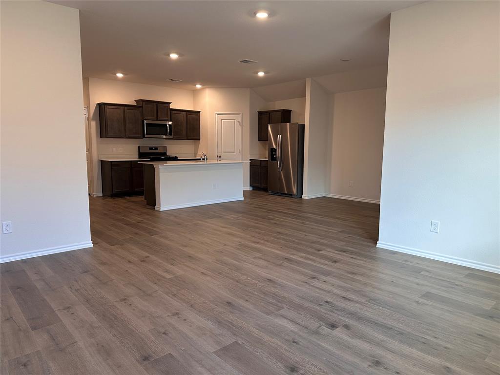 3917 Turquoise Avenue Celina, TX 75009 - Photo 2 of 19 a view of kitchen with refrigerator stove and wooden floor