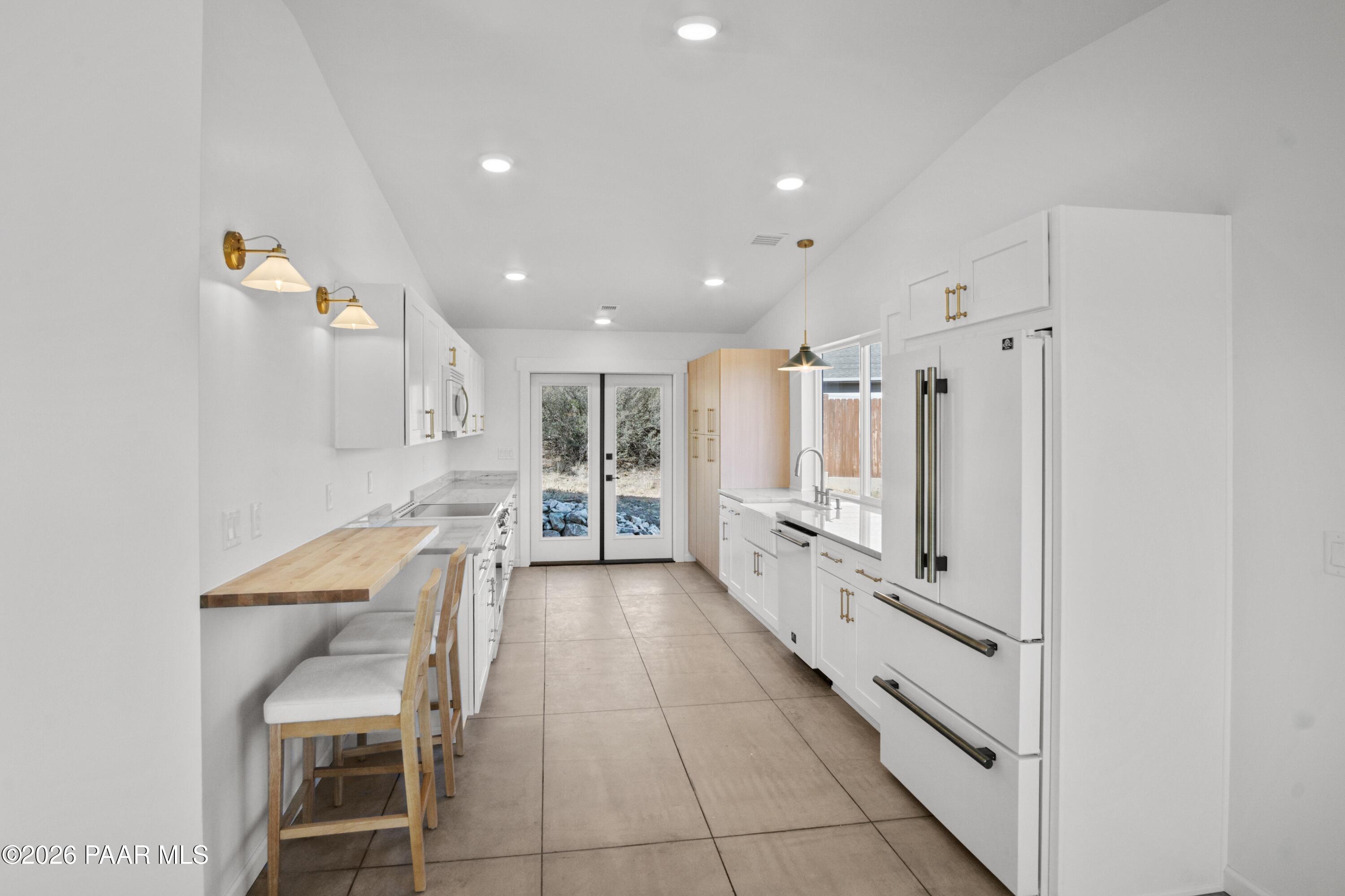 4920 East Amber Road Prescott, AZ 86301 - Photo 11 of 38 a kitchen with white cabinets and chairs