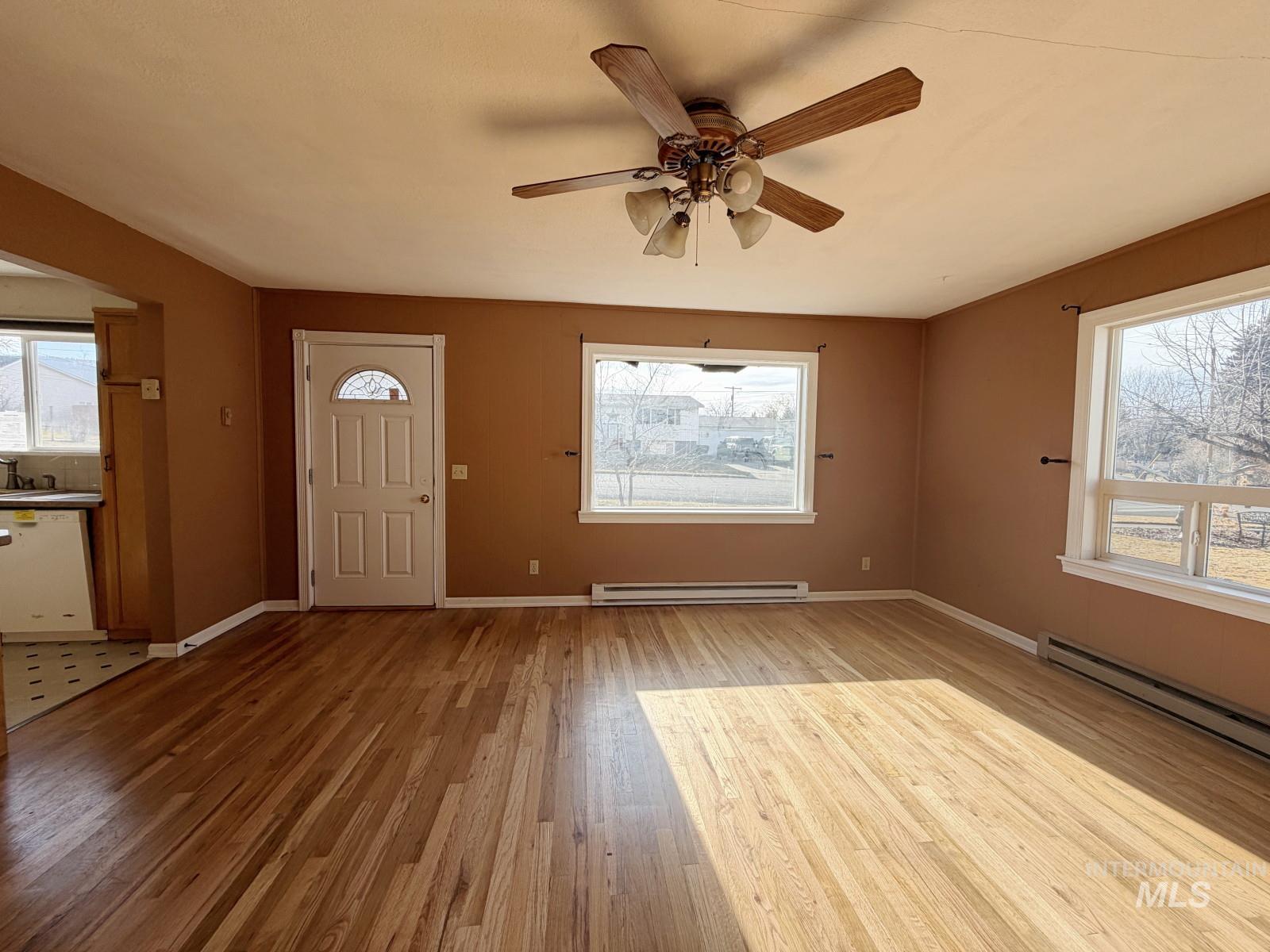 101 Southeast 7th Street Grangeville, ID 83530 - Photo 3 of 23 Entrance foyer featuring light wood finished floors, ceiling fan, and a baseboard radiator