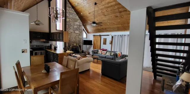 a kitchen with stainless steel appliances granite countertop a refrigerator a stove and a sink with wooden floor