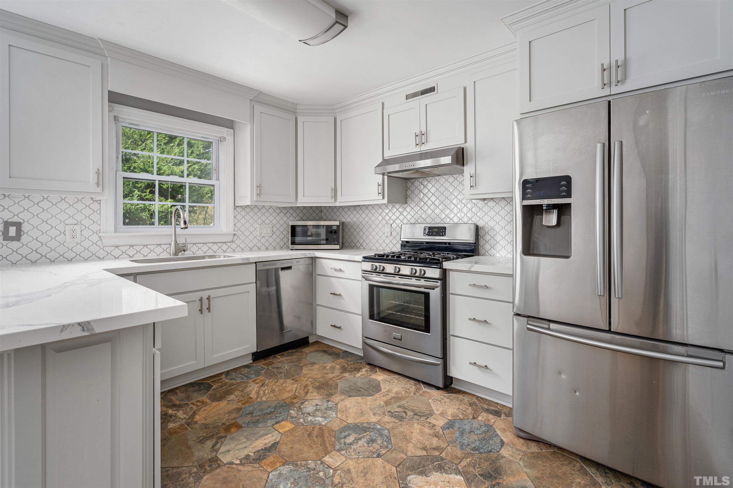 5219 Cardinal Grove Boulevard Raleigh, NC 27616 - Photo 15 of 43 a kitchen with white cabinets and stainless steel appliances