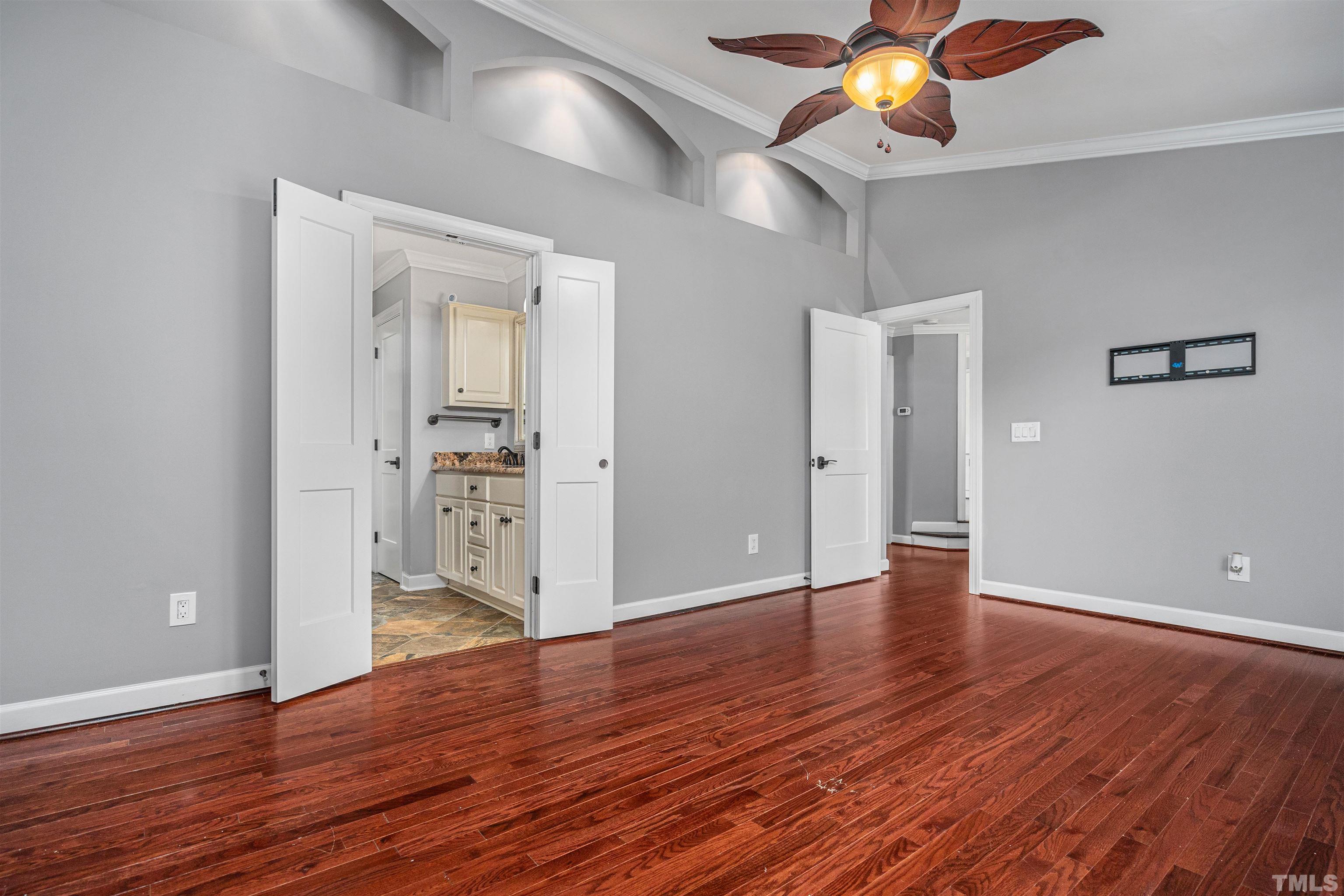 5219 Cardinal Grove Boulevard Raleigh, NC 27616 - Photo 25 of 43 a view of an empty room with wooden floor and a ceiling fan