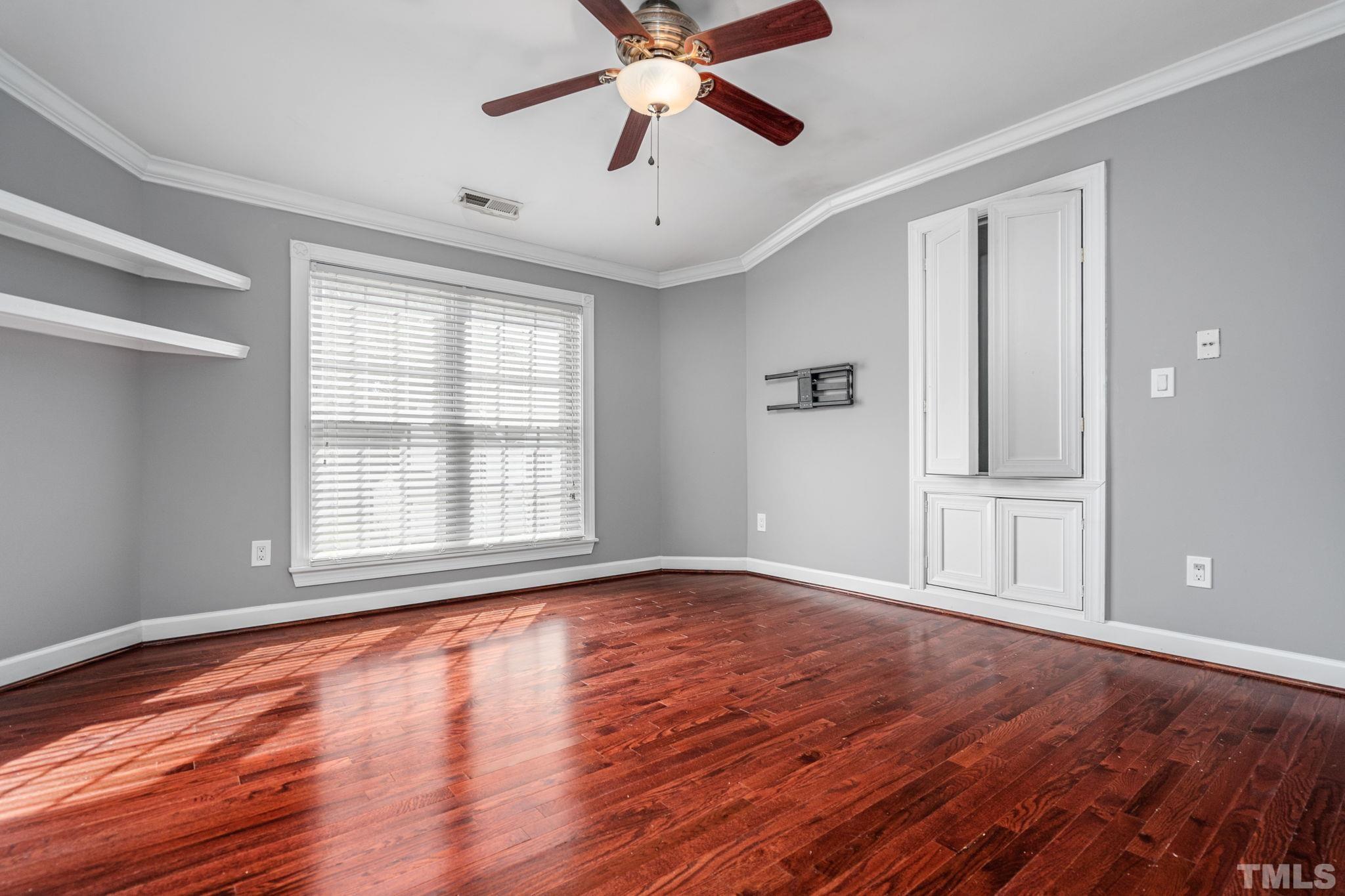 5219 Cardinal Grove Boulevard Raleigh, NC 27616 - Photo 35 of 43 a view of an empty room with wooden floor and a window