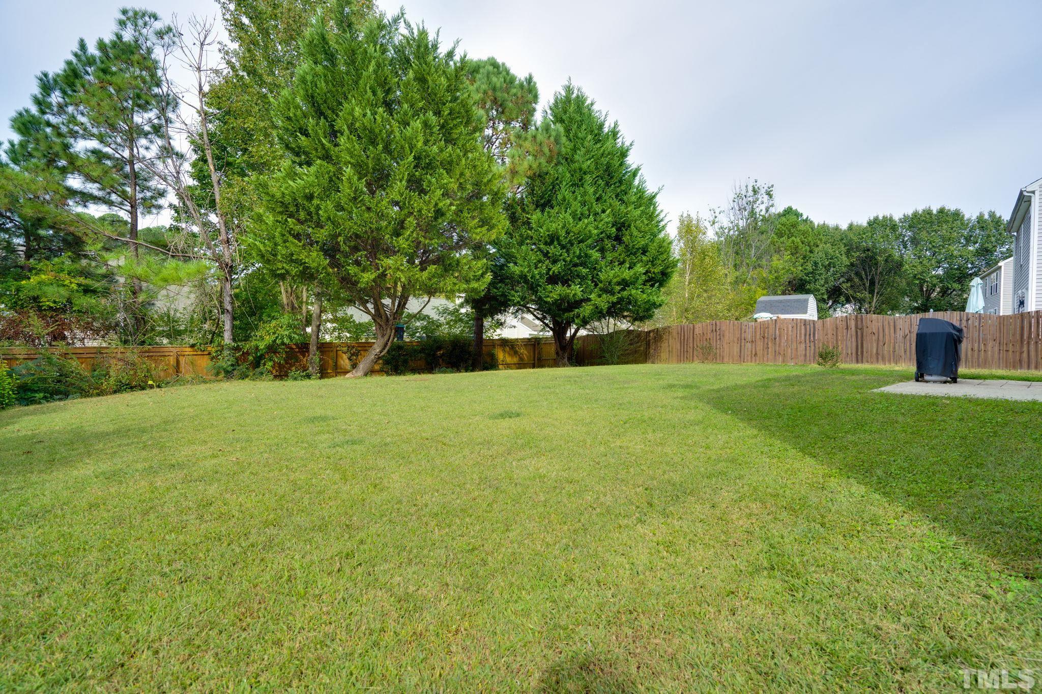 5219 Cardinal Grove Boulevard Raleigh, NC 27616 - Photo 42 of 43 a view of green field with trees in the background