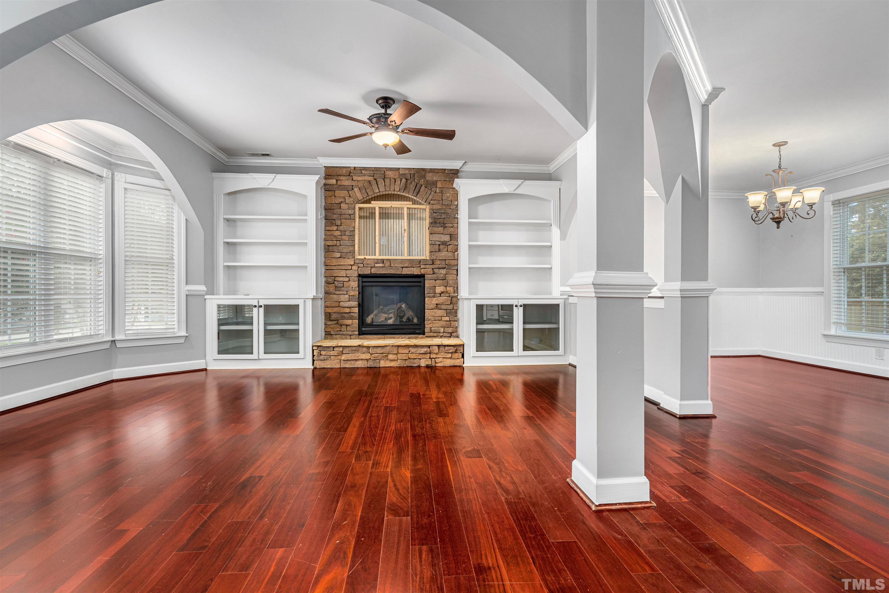 5219 Cardinal Grove Boulevard Raleigh, NC 27616 - Photo 5 of 43 an empty room with wooden floor fireplace and windows