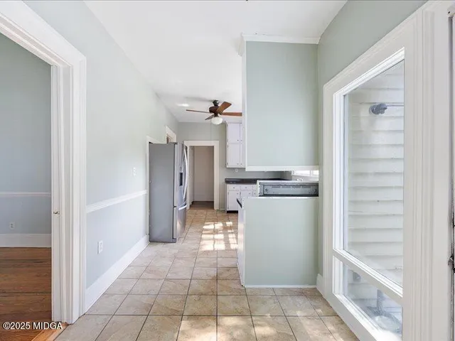 a kitchen with a refrigerator and white cabinets