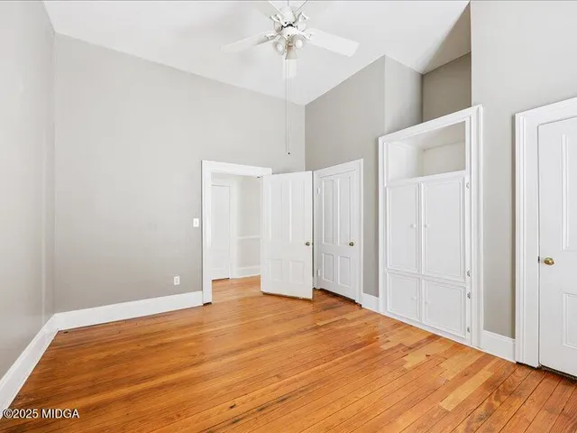 a view of empty room with wooden floor