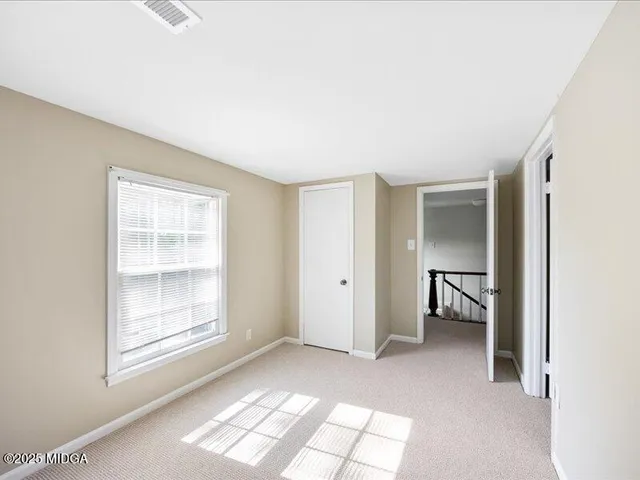 a view of empty room with window and bathroom