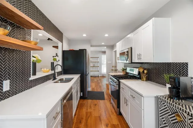 a kitchen filled a sink a counter top space and stainless steel appliances