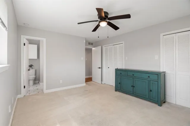 a view of a livingroom with a chandelier fan and a window