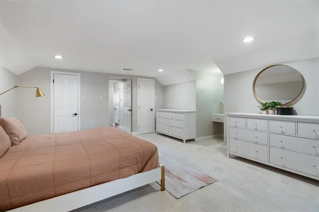 a spacious bedroom with a large bed and a chandelier