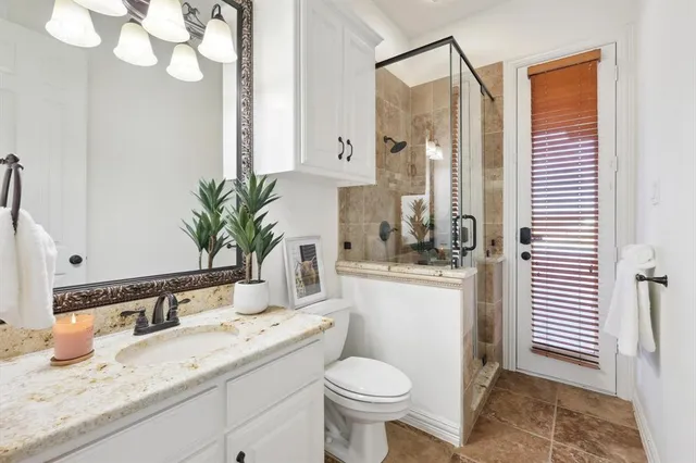 a bathroom with a granite countertop sink a toilet and a mirror