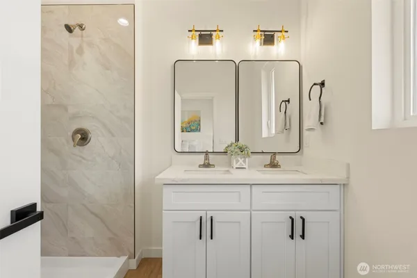a bathroom with a double vanity sink a mirror and shower
