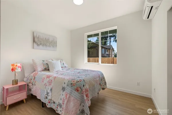 a bedroom with a bed and wooden floor