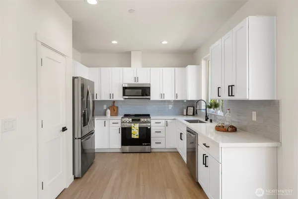 a kitchen with white cabinets and stainless steel appliances