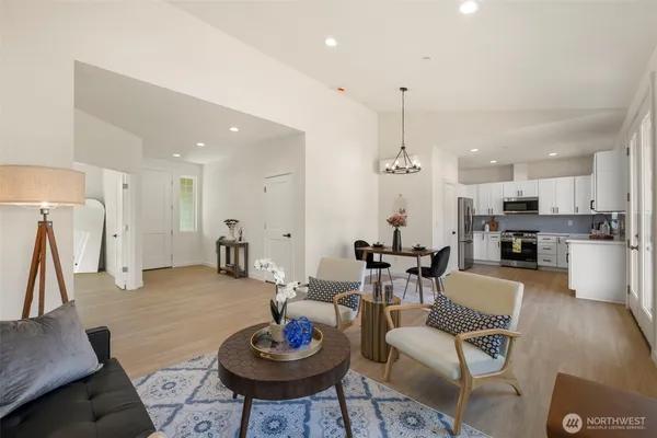 a living room with furniture and a dining table with kitchen view