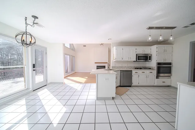 a kitchen with stainless steel appliances granite countertop a refrigerator sink and white cabinets