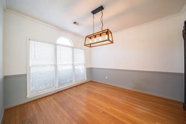 a view of a livingroom with a chandelier fan and windows