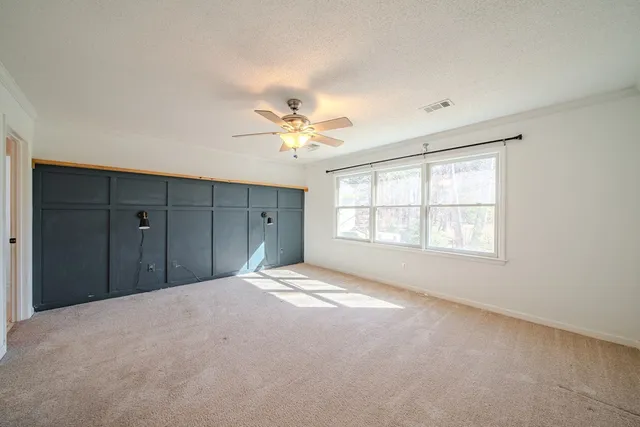 an empty room with closet and a chandelier fan